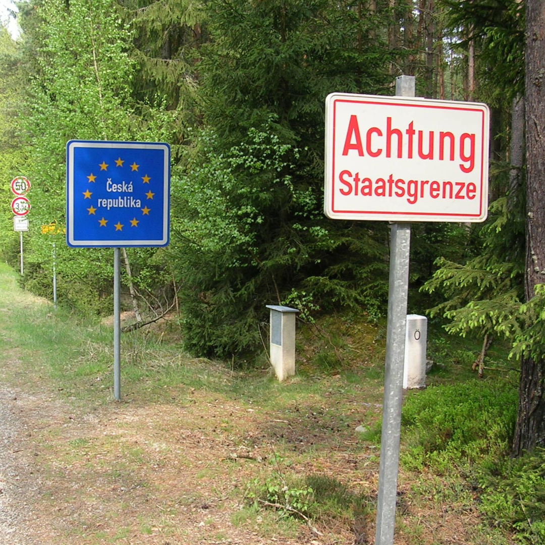 Border between Austria and the Czech Republic. In front there is a German language sign warning about the border. Behind it there is a blue sign post with the European Union starts and a blue background announcing the Czech Republic.
