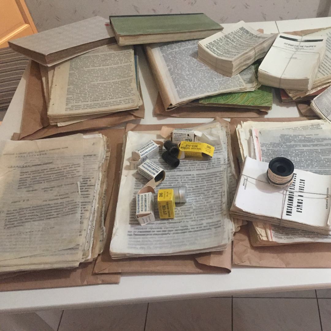 Samizdat documents laid out neatly on a table. On top of the document stash in the middle there are a number of camera film containers.